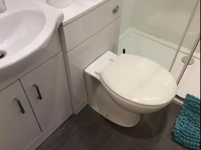 a white bathroom with a toilet and a sink at 103 NELSON STREET Aubery in Largs