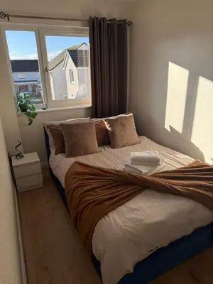a bedroom with a large bed with a window at Black Daisy in Glasgow