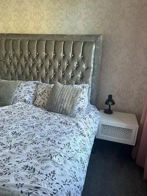 a bedroom with a bed with a white comforter at Black Daisy in Glasgow
