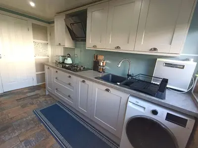 a kitchen with a sink and a washing machine at Double room in riverside apartment in Glasgow