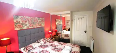 a bedroom with pink walls and a bed and a mirror at Double room in riverside apartment in Glasgow