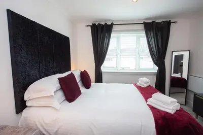 a bedroom with a large white bed with red pillows at Modern 3 Bed Flat Balloch in Jamestown