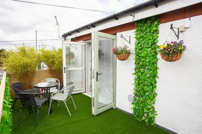 a patio with a table and chairs and plants at Modern 3 Bed Flat Balloch in Jamestown