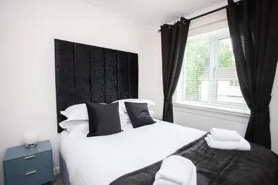a bedroom with a large white bed and a window at Modern 3 Bed Flat Balloch in Jamestown