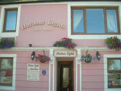 a pink building with flowers on the front at Harbour Lights Guesthouse in Stranraer