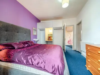 a bedroom with purple walls and a large bed at Bay View in Oban
