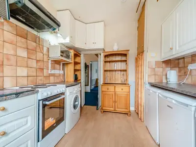 a kitchen with white appliances and wooden cabinets at Bay View in Oban