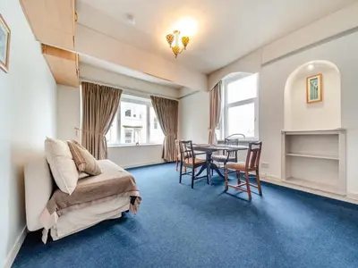 a room with a bed and a table and chairs at Bay View in Oban