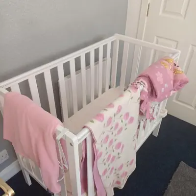 a white crib with a pink blanket on it at Bay View in Oban