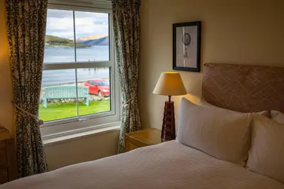 a bedroom with a bed and a window with a view at The Pierhouse Hotel in Port Appin