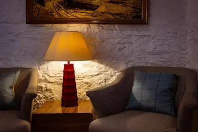 a lamp sitting on a table next to two chairs at The Pierhouse Hotel in Port Appin