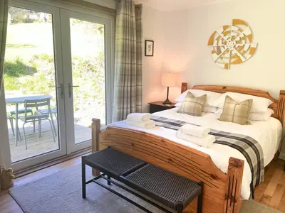 a bedroom with a bed and a sliding glass door at Bruach in Balquhidder