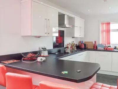 a kitchen with white cabinets and a black counter top at Wallace View in Stirling