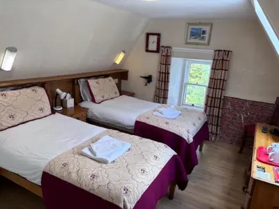 a hotel room with two beds and a window at Cumberland Hotel in Edinburgh