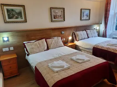 a hotel room with two beds with towels on them at Cumberland Hotel in Edinburgh
