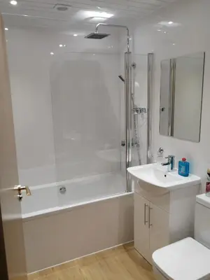 a bathroom with a tub and a sink and a shower at Cumberland Hotel in Edinburgh