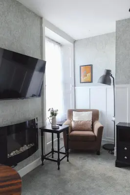 a living room with a chair and a fireplace at Carvetii - Meg's Studio - 1st Floor, Dunfermline City Centre in Dunfermline