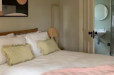 a bed with white pillows and a sink in a room at Montagu in Thornhill