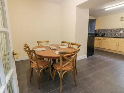 a dining room table with chairs and a kitchen at West Morton House in Thornhill
