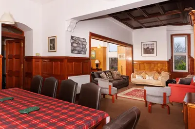 a living room with a table and chairs at Garmoyle House & Garmoyle Mid Cottage in Dumbarton