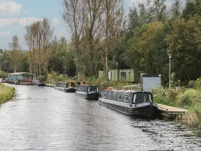 a group of boats are docked on a river at Elm in Denny