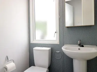 a bathroom with a white toilet and a sink at Oak in Denny