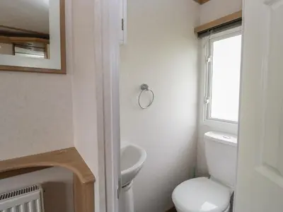 a bathroom with a toilet and a sink and a window at Willow in Denny