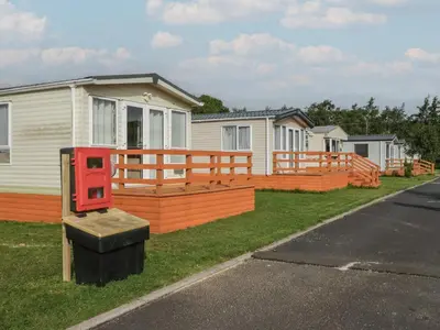 a house with a large deck with a house at Hazel in Denny