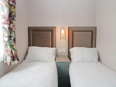 two beds sitting next to each other in a room at Yew in Denny