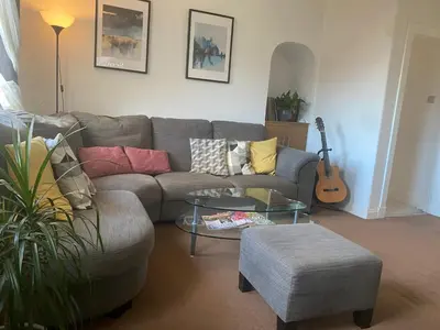 a living room with a couch and a table and a guitar at Frans Place in Edinburgh