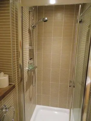 a bathroom with a shower and a bath tub with a shower at Violet Bank Apartment New Town in Edinburgh