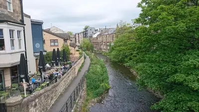 a river in the middle of a city with buildings at Violet Bank Apartment New Town in Edinburgh