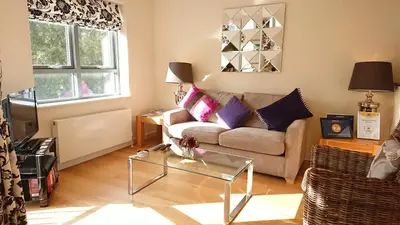 a living room with a couch and a table at Violet Bank Apartment New Town in Edinburgh