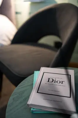 a book sitting on top of a table next to a chair at 24 Kingsford Court in Newton Mearns