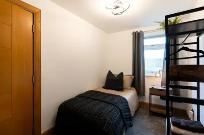 a small bedroom with a bed and a window at 24 Kingsford Court in Newton Mearns