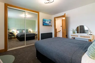 a hotel room with a bed and a mirror at 24 Kingsford Court in Newton Mearns