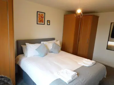 a bedroom with a bed with white sheets and pillows at No 52 - Newly refurbished 3 bedroom home in East Kilbride in East Kilbride