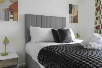 a bedroom with a bed with a black and white comforter at Redding House in Falkirk