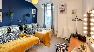 two beds in a room with blue walls at Flat for 6 guests near Glasgow, Loch Lomond in Dumbarton