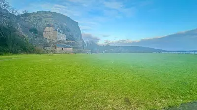 a large field of grass with a mountain in the background at Flat for 6 guests near Glasgow, Loch Lomond in Dumbarton