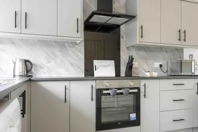 a kitchen with white cabinets and a stove top oven at Granby House in Livingston