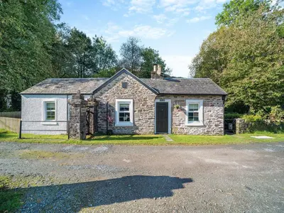 a stone house with a driveway in front of it at North Lodge in Colintraive