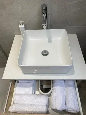 a white sink in a bathroom with towels at 6 Smithhills - Sleeps 3 Central Excellent Transport Links Glasgow & Airport in Paisley