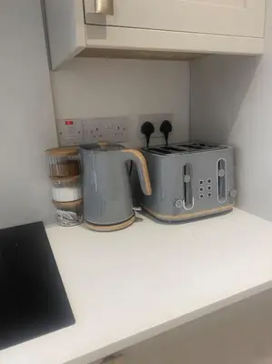 a kitchen counter with two toasters and a toaster at 5 Smithhills Paisley Central GLW & Glasgow access in Paisley