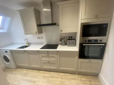 a white kitchen with a sink and a microwave at 5 Smithhills Paisley Central GLW & Glasgow access in Paisley