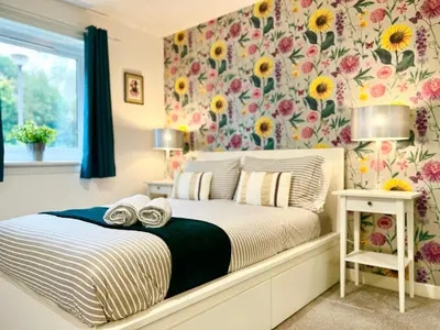 a bedroom with a bed with sunflower wallpaper at Ground Floor Flat with Free Parking & WiFi in Glasgow