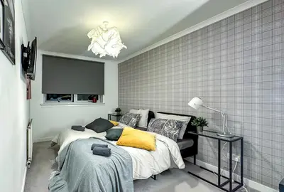 a bedroom with two beds and a chandelier at Brand New Scotland home 3rooms near Glasgow in Clydebank