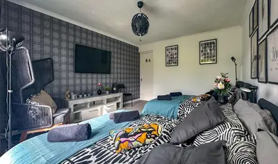 a bedroom with two beds and a flat screen tv at Brand New Scotland home 3rooms near Glasgow in Clydebank