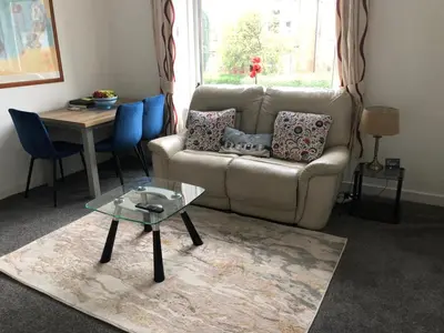 a living room with a couch and a table at Victorian Flat in Bonhill