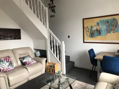 a living room with a couch and a table at Victorian Flat in Bonhill